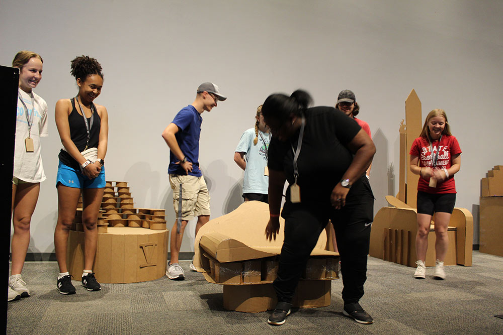 Students standing around their finished cardboard chair project