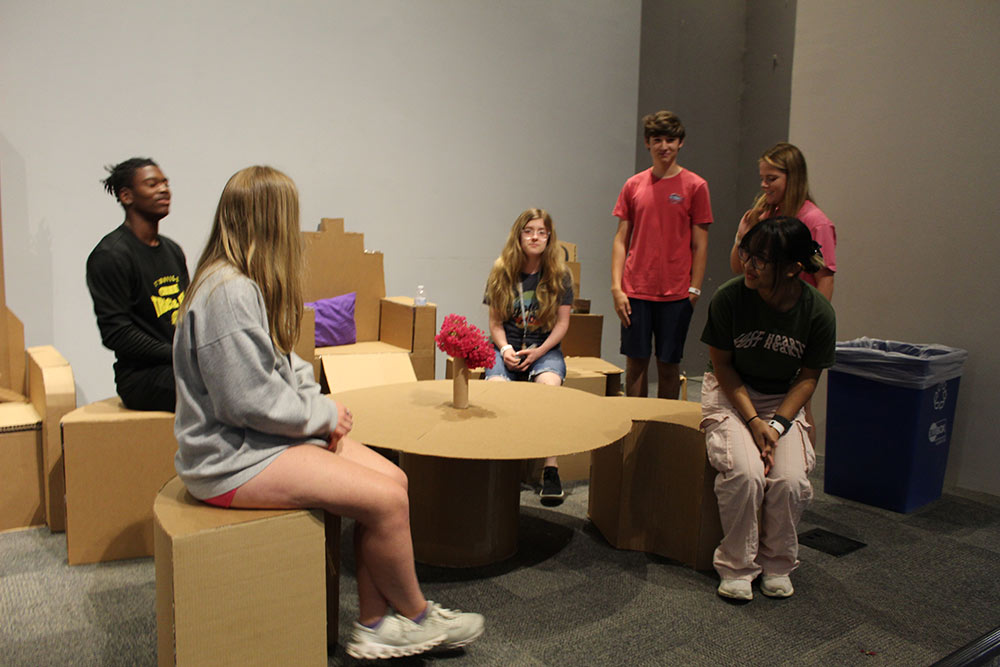 Group of campers sitting on their cardboard chair project.