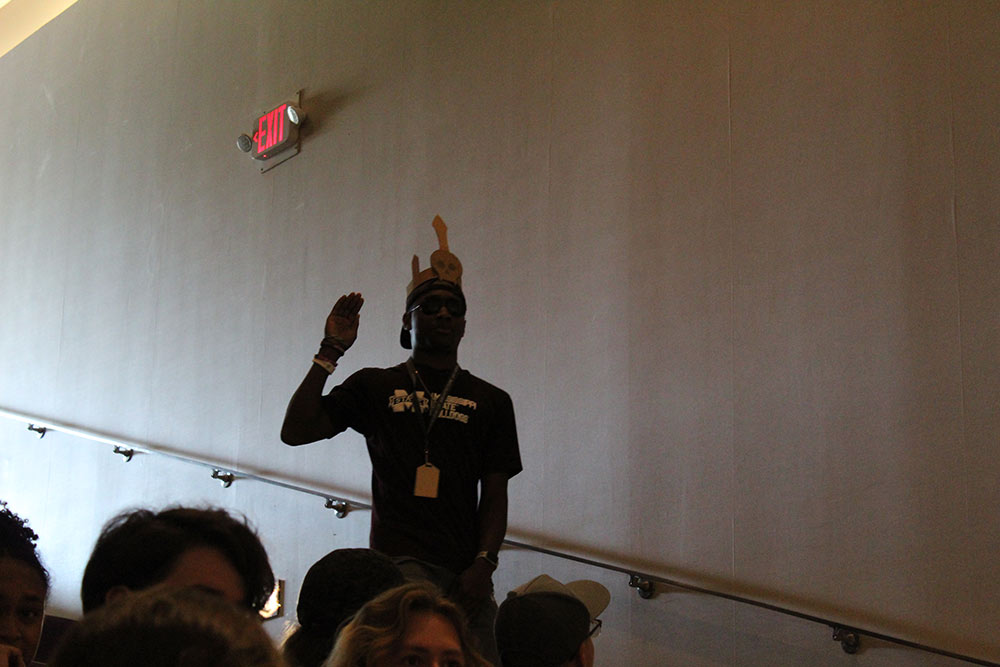 Design Discovery camper posing in the auditorium with a cardboard crown around his head.