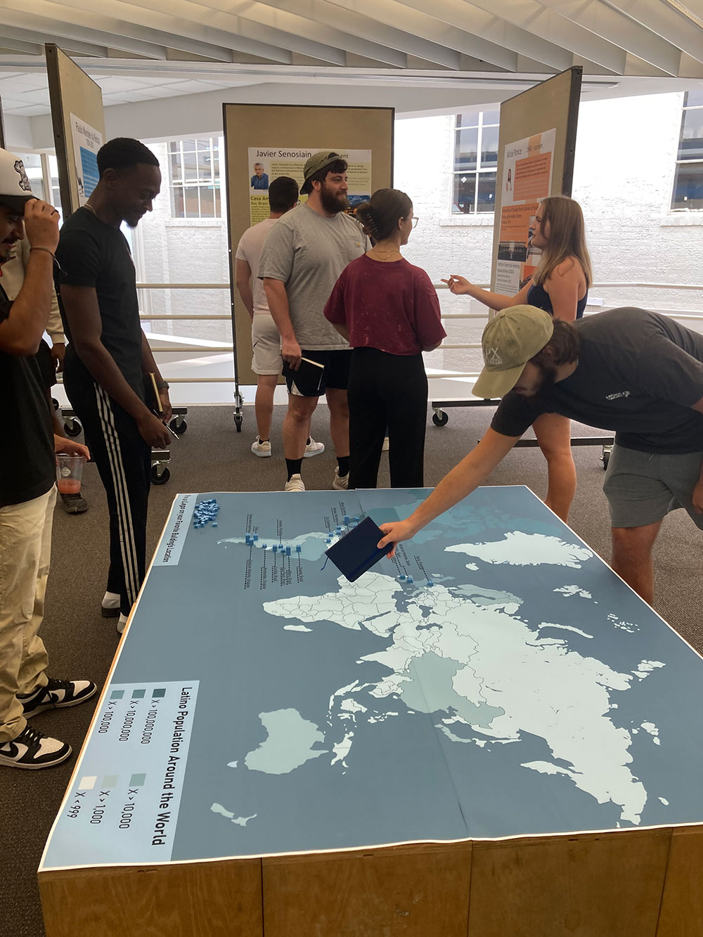 Groups of students interacting with a map and its pieces.