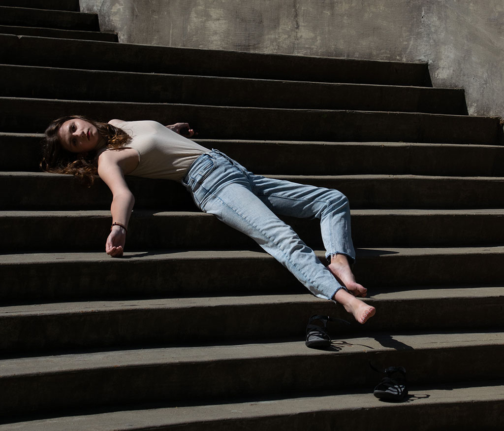 Photograph of a person reclining on stairs.