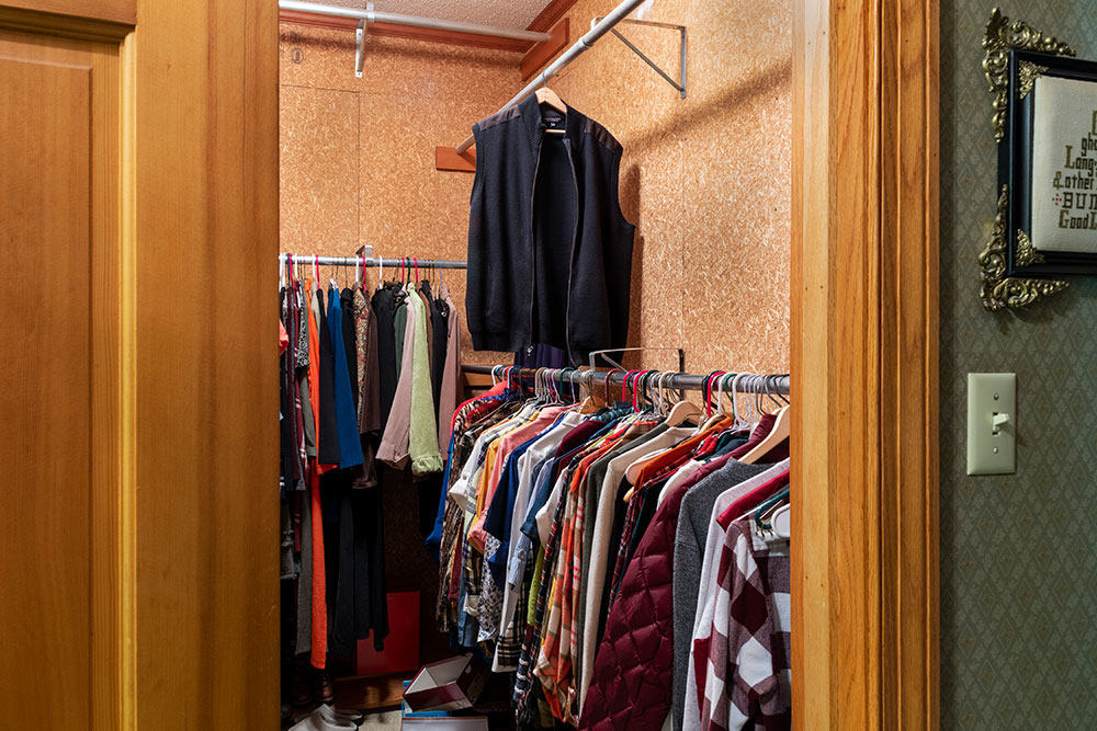 view of one side of a closet with clothes hanging