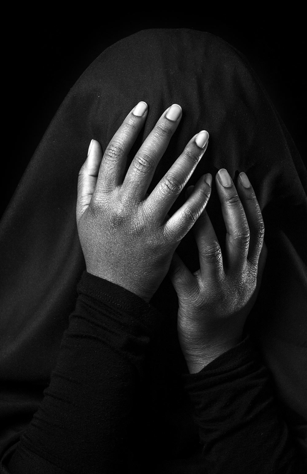 black and white shot of person covering their face with hands