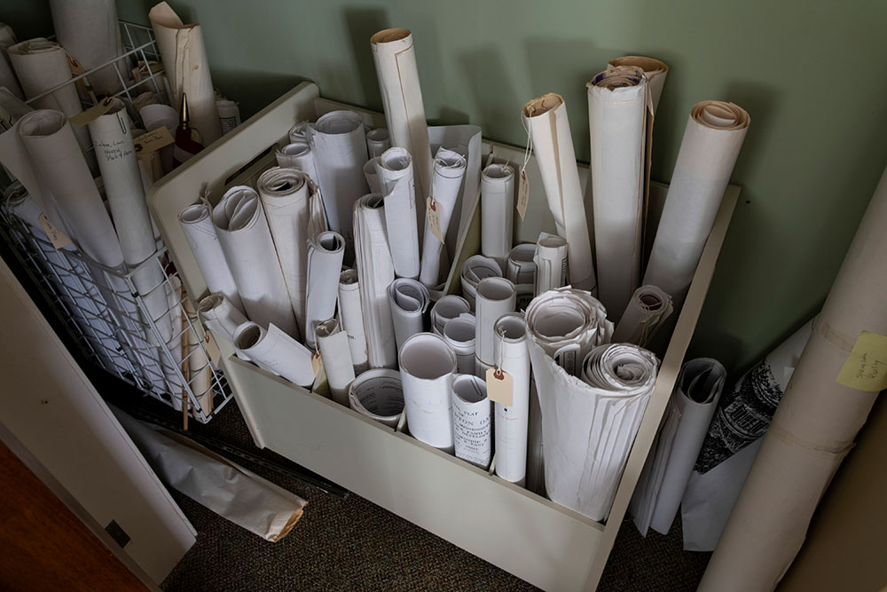long sheets of paper rolled up in bins - possibly blue prints