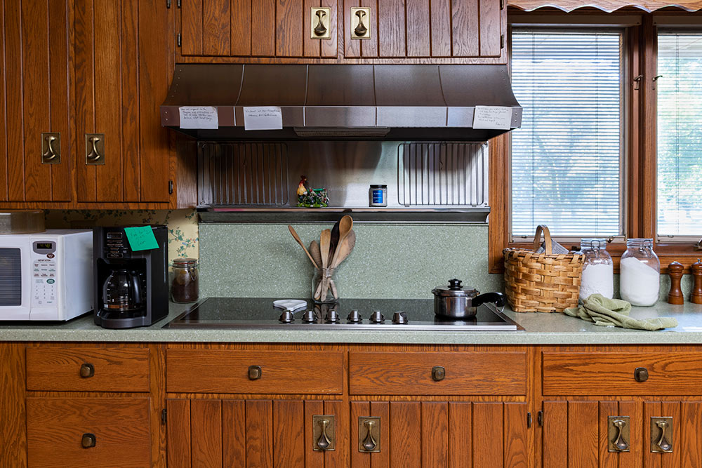 view of kitchen stove, counter, microwave - 2 handwritten notes are posted to range top
