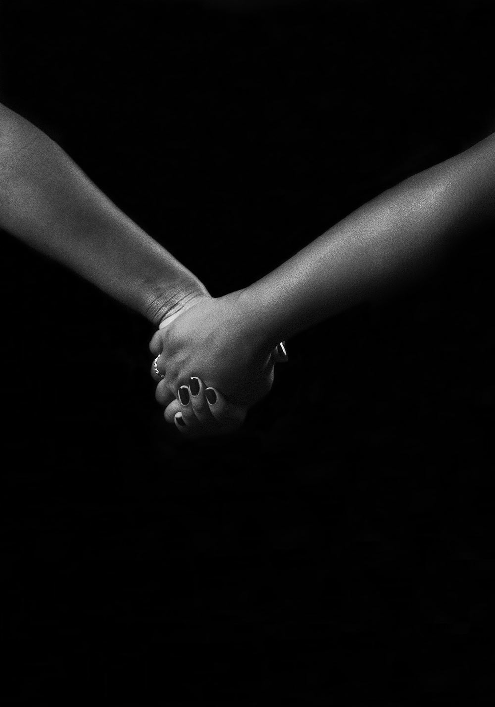 black and white image of two people holding hands