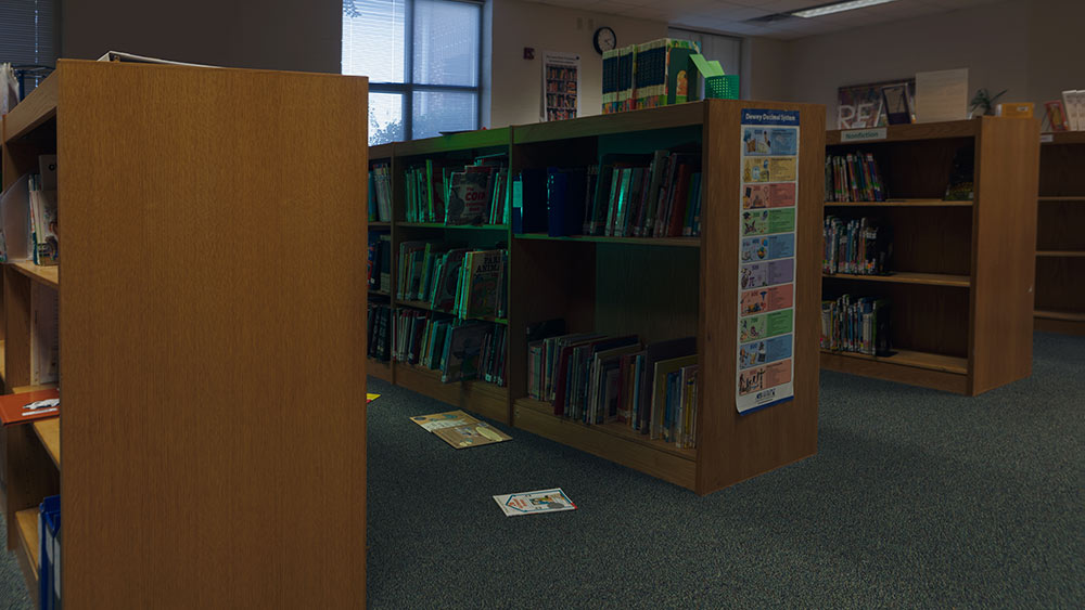 shelves of books at library with green light glow