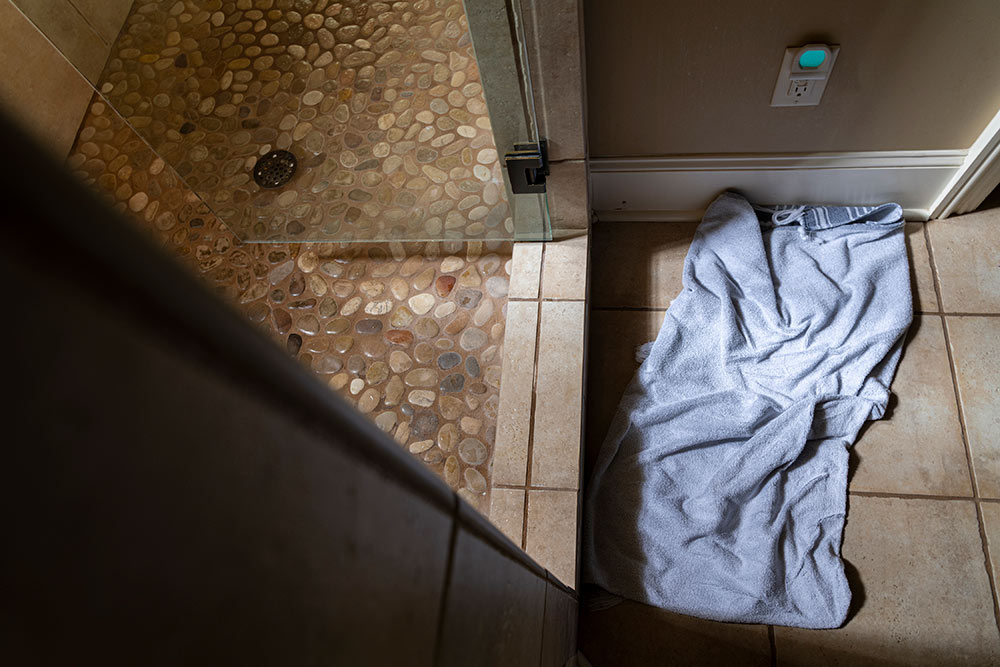 view of bathroom floor - towel shown on floor outside of shower