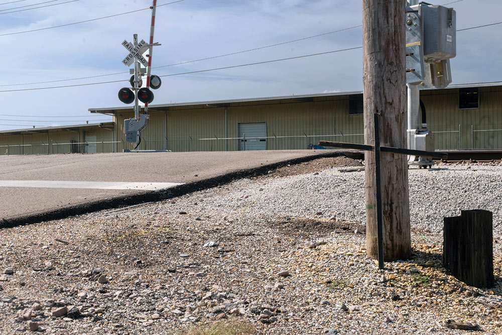 cross in front of pole at train crossing intersection