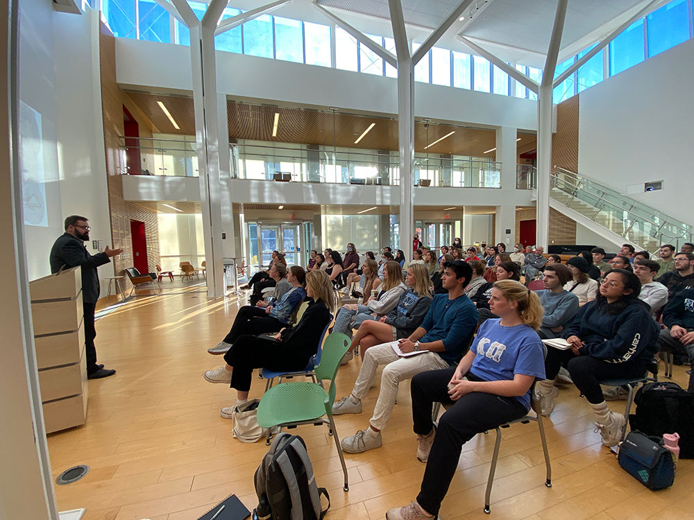 Hans Herrmann, front left, talks to large group seated in rows at James Madison University