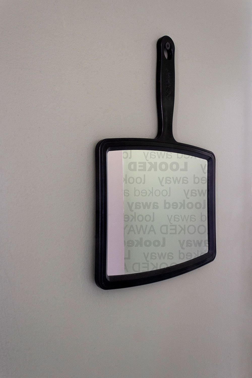 mirror hanging upside down on wall; "looked away" written on it