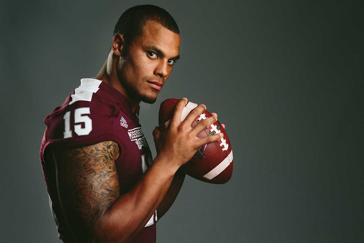 Football player, quarterback, posing for photo holding football