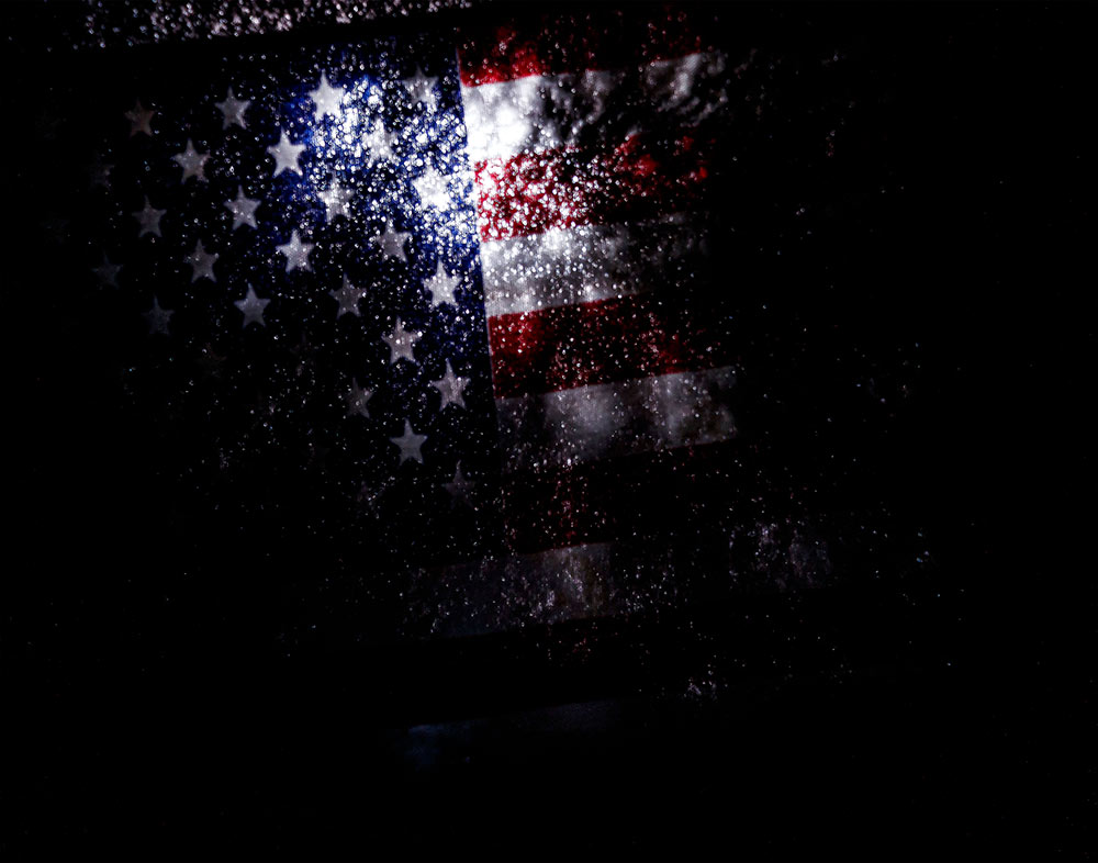 dark image - part of American flag can be seen at top center