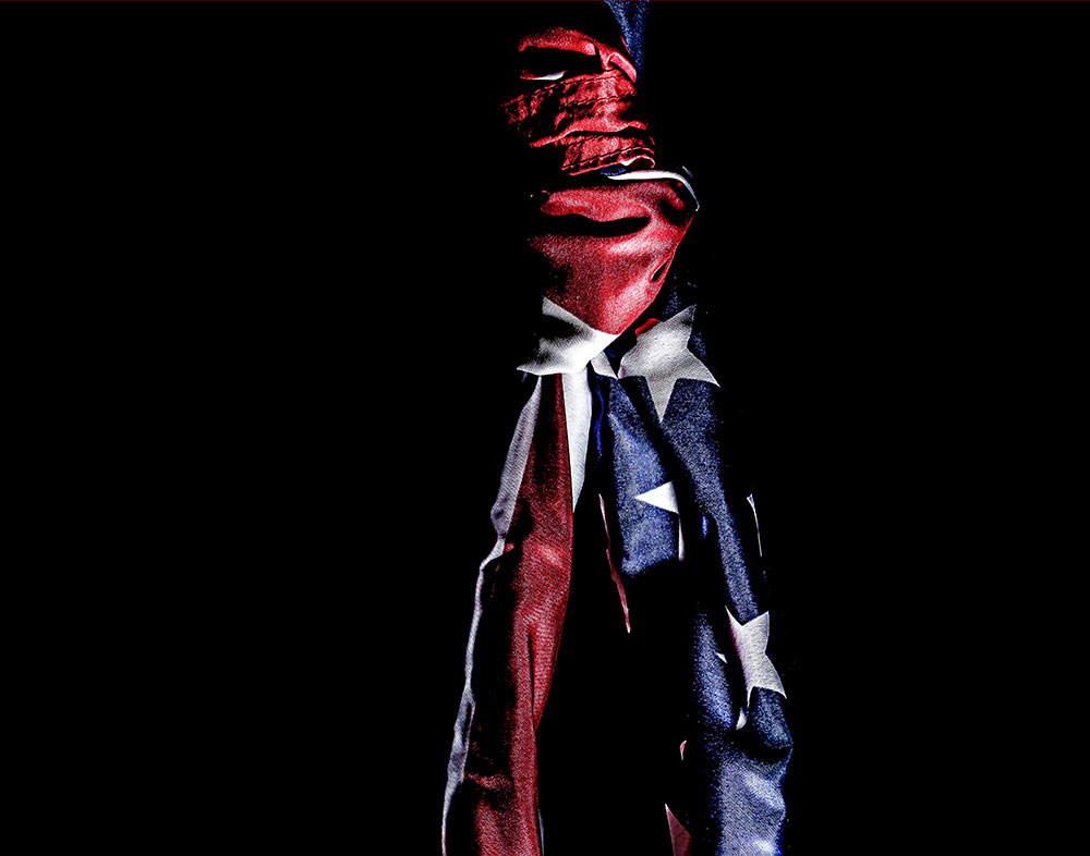 tied American flag in center of black background
