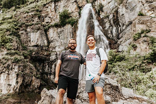 Gines, left, with Necaise in front of a waterfall