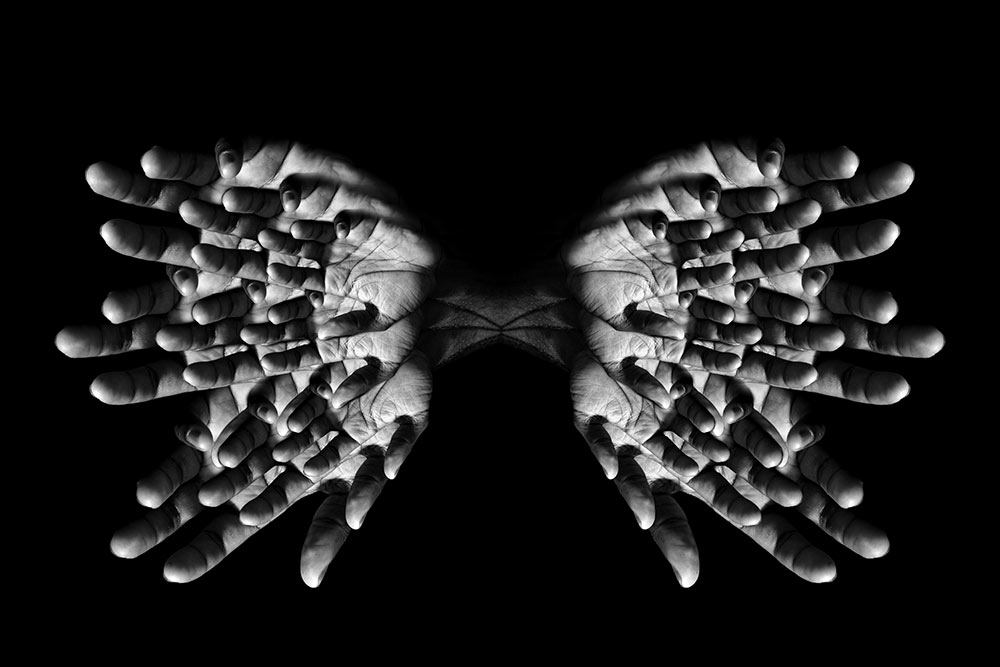 black and white image of fingers in pattern to look like butterfly