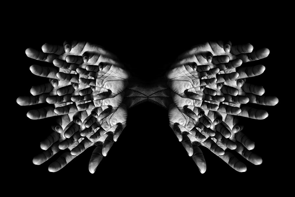 black and white image of fingers in pattern to look like butterfly