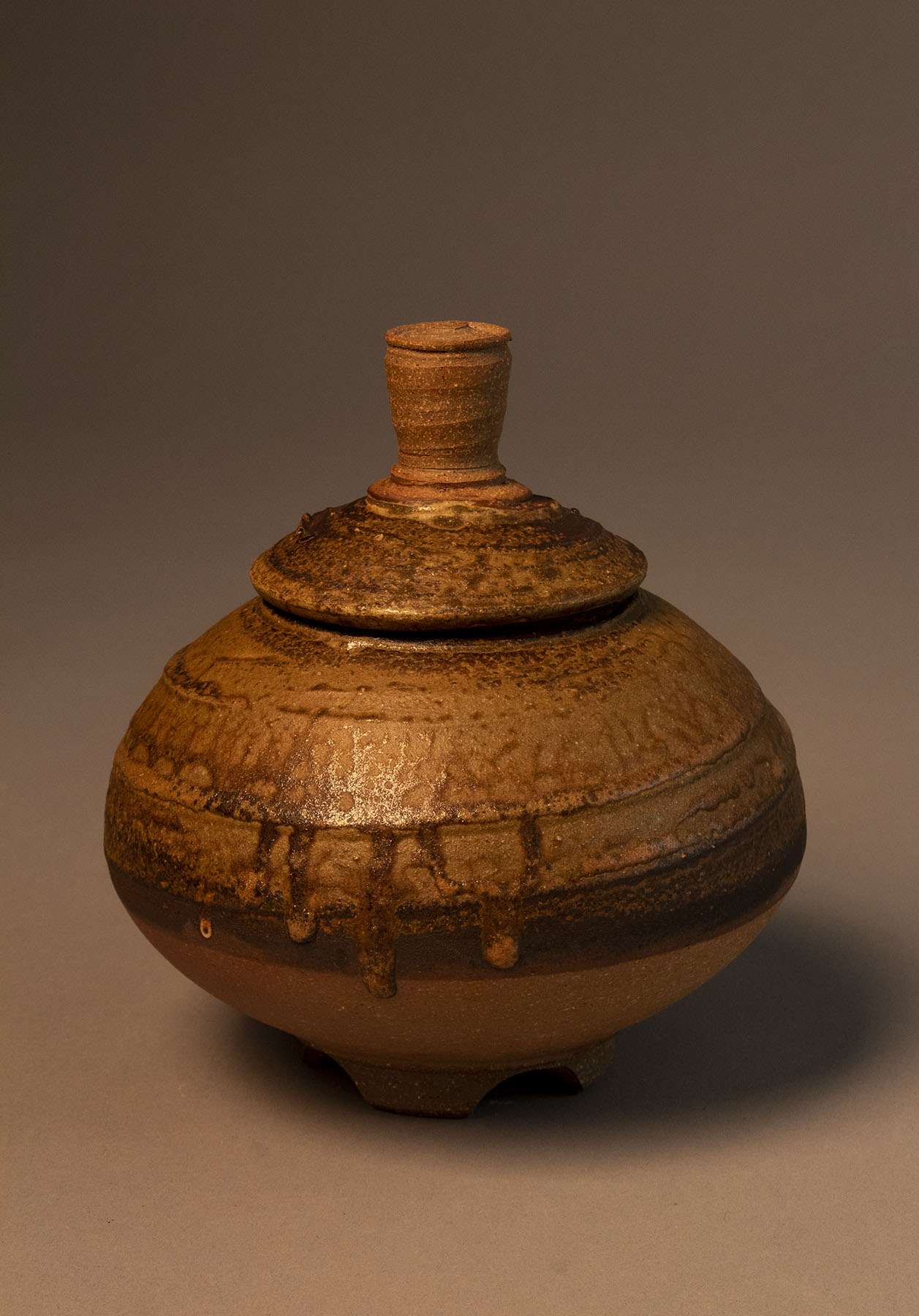 A very similar jar to the one previously described but with a squatter profile. The edge of the lid comes closer to touching the shoulder on this jar as well and the neck is totally obscured. The ash seems to flux a bit more actively on this pot (likely due slightly to thicker application) in some spots the fluxing ash has formed into drips that have flowed down the side of the pot.