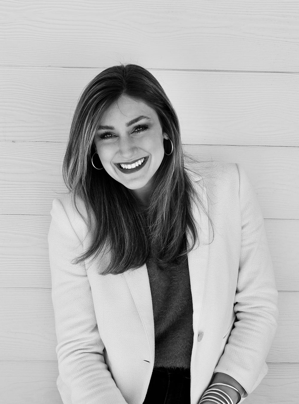 black and white headshot of Alexis Bartlewski in front of house with white siding