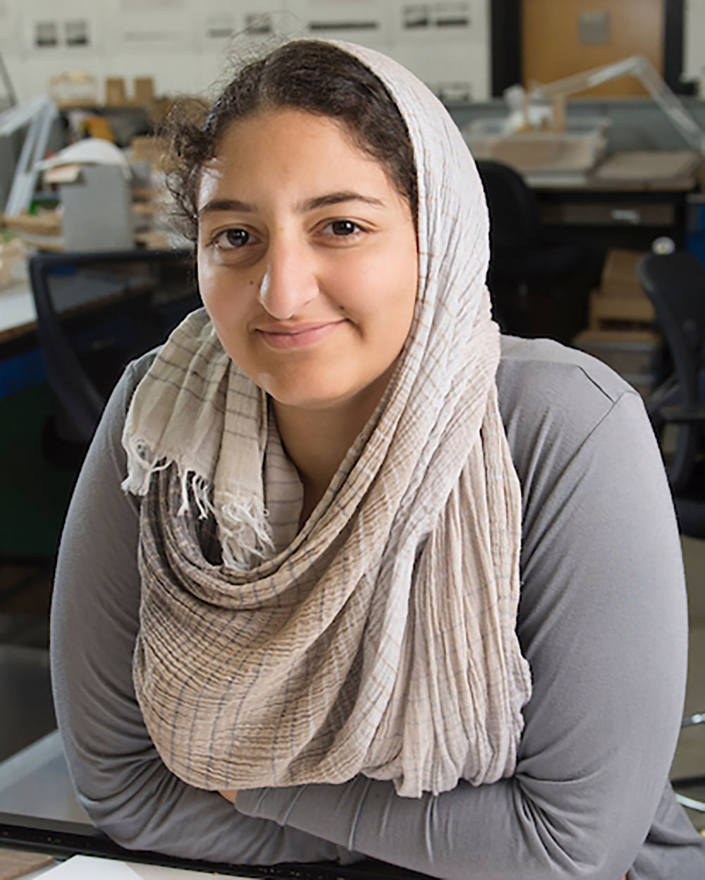 Nada Abdel-Aziz leans on desk and poses