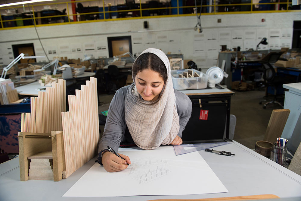 Nada Abdel-Aziz draws at her desk in Giles Hall