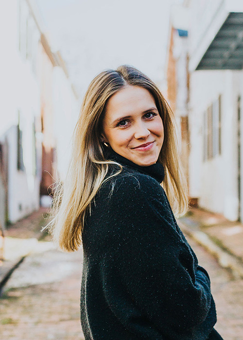 Ashley Ensor poses in black shirt in alley