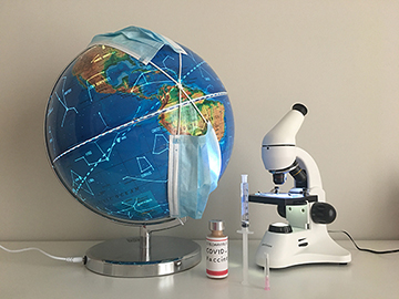 Photograph of a globe, microscope, and facemask.