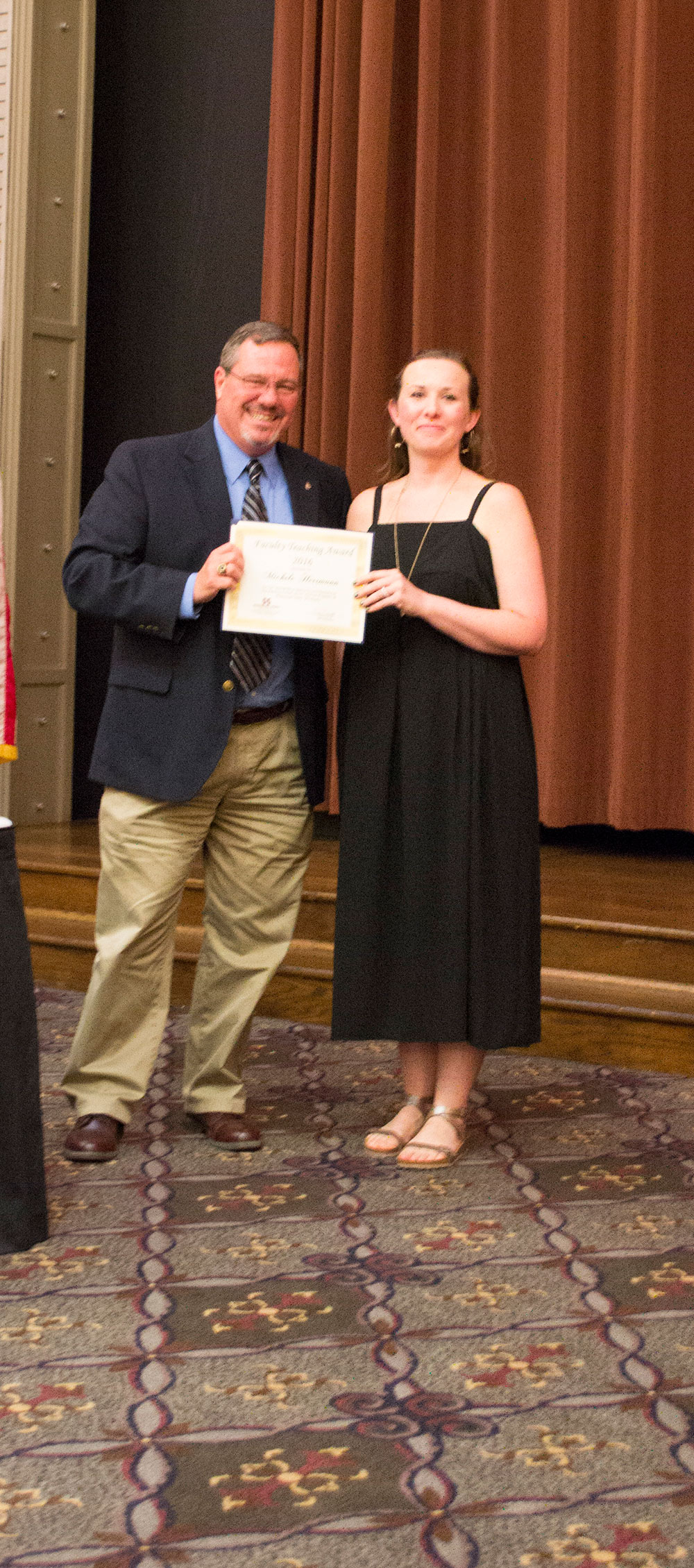 Craig Capano, left, presents award to Michele Herrmann