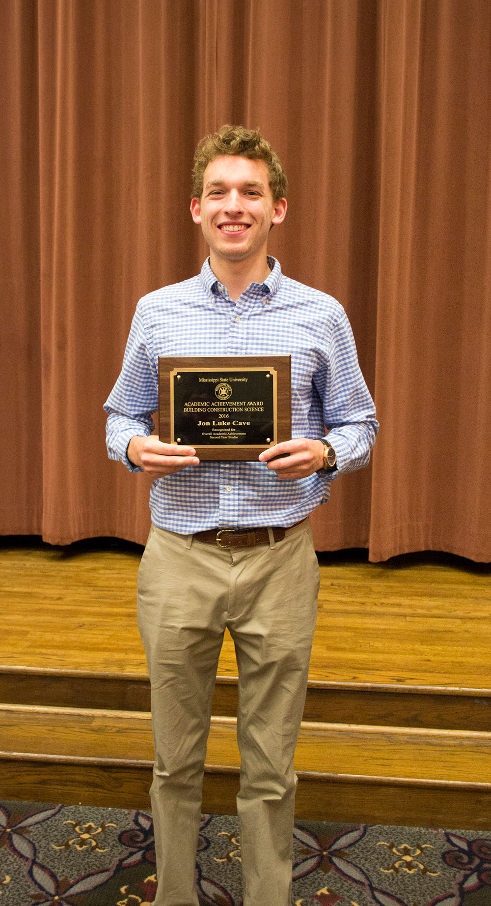 John Luke Cave holds student of the year plaque