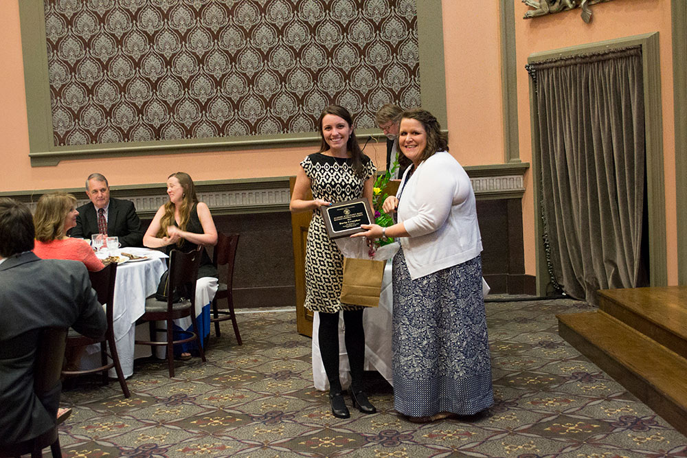 Devin Compher, left, accepts award from Laura Mitchell