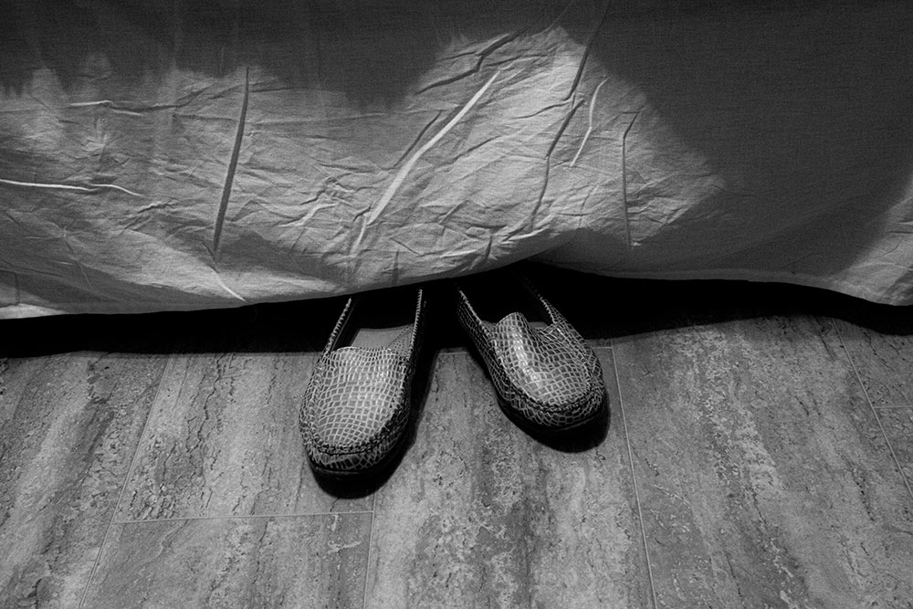 black and white photo by MSU photo student Maurissa Shumpert of slippers under bed