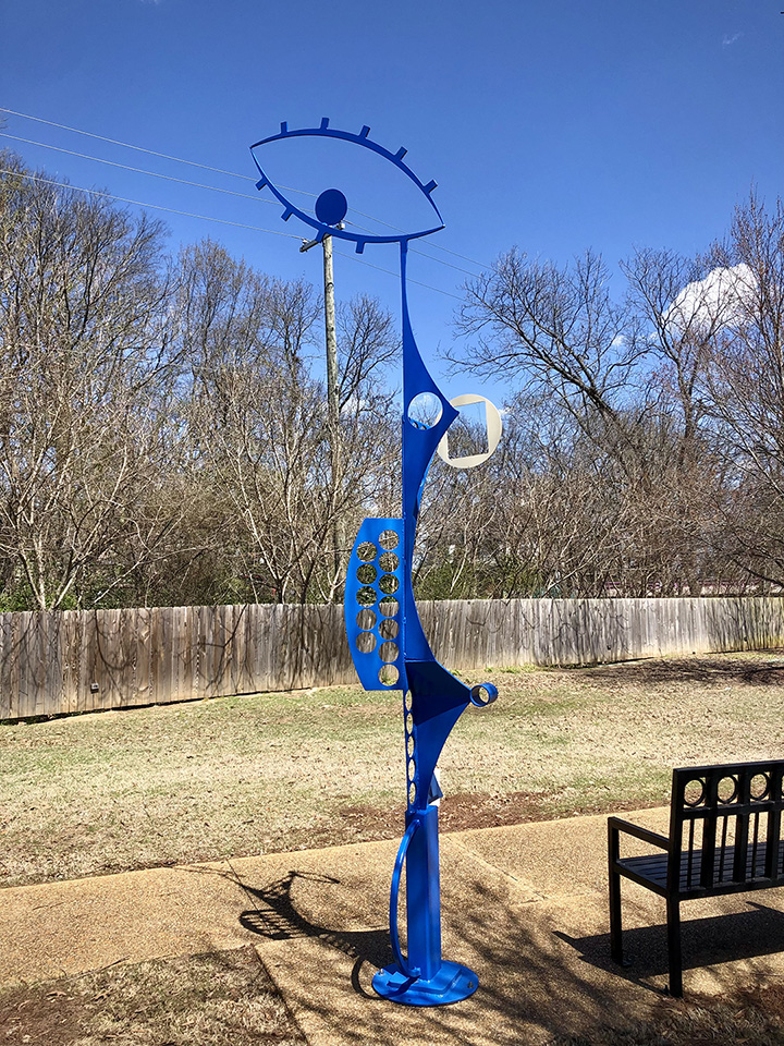 Statue of a metal sculpture painted blue in an outdoor park.