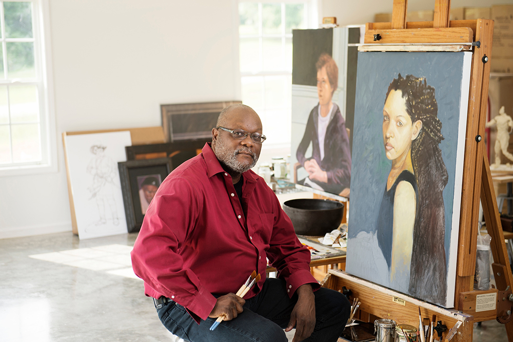 Alex Bostic sits in his studio