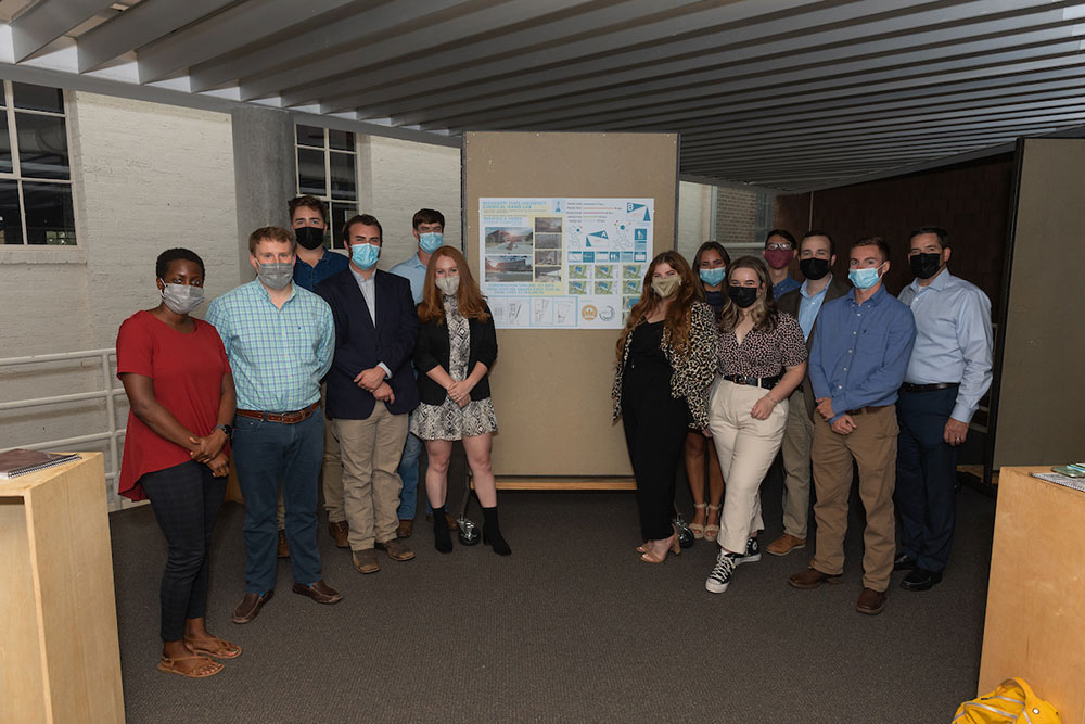 group poses in Charlotte and Richard McNeel Gallery in Giles Hall