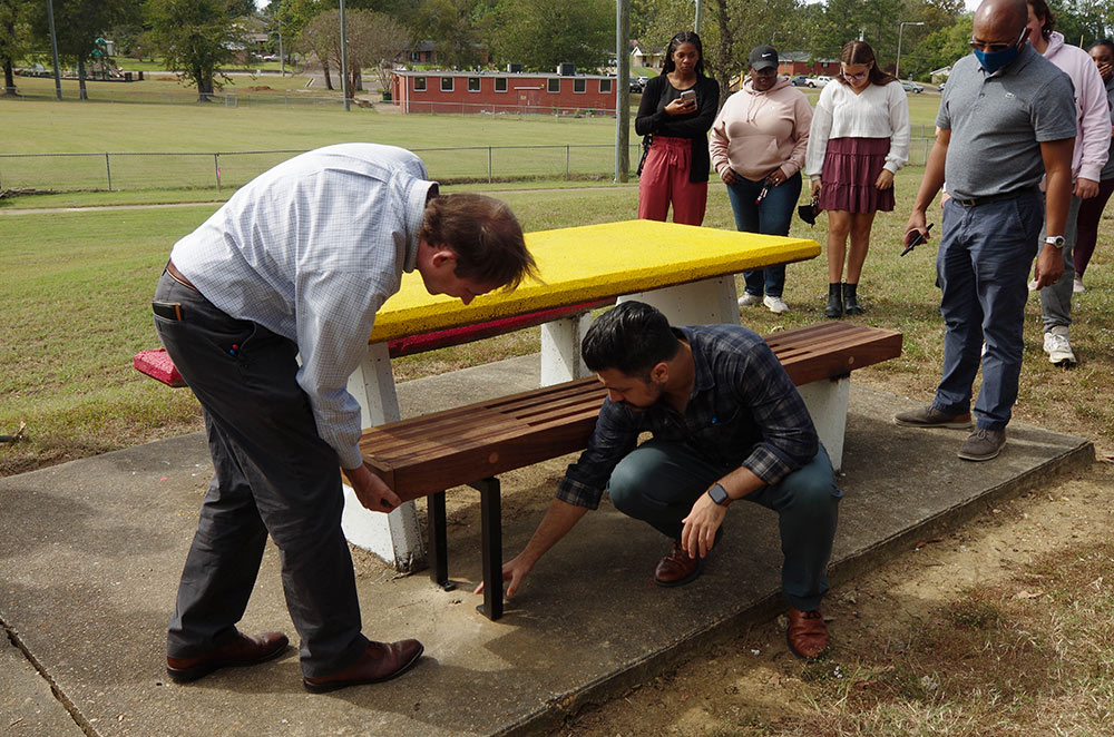 Professors in the MSU Collaborative Studio inspect students' bench design at a Starkville park