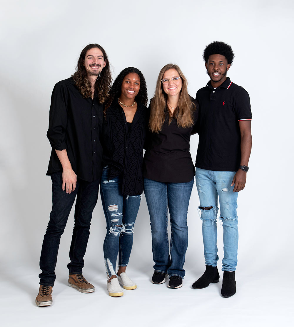 students wearing black shirts and jeans pose. Left to right: Bryce Camp, Hailey Farrington-Bentil, Sloane Bush, and Kyler Moore