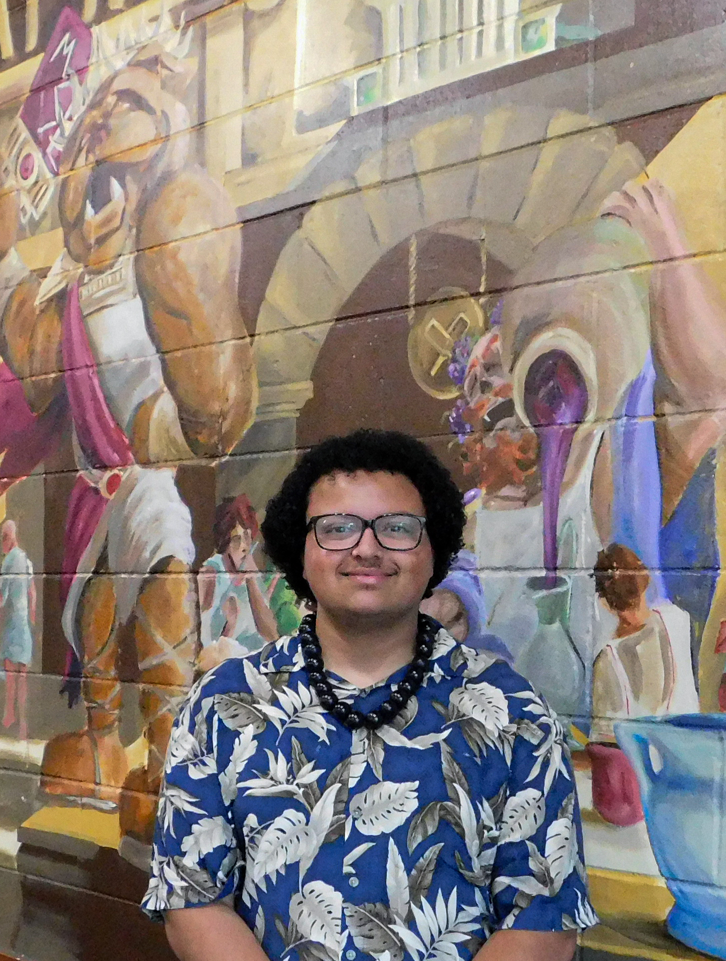 William "Donovan" Weathers II stands in front of his recent mural, "Greek Life at Pita Pit."