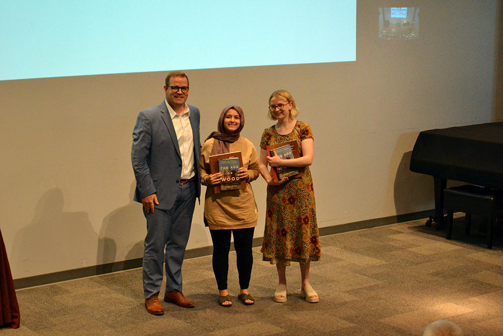 Professor Jake Gines stands with, center, Gizem Karsi, and Jacquelin Lee, right