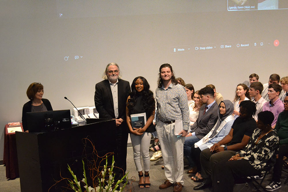 Jassen Callender stands with two students on stage