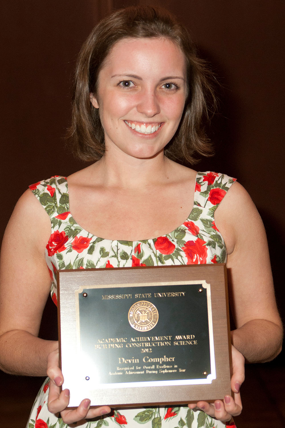 Devin Compher holds award