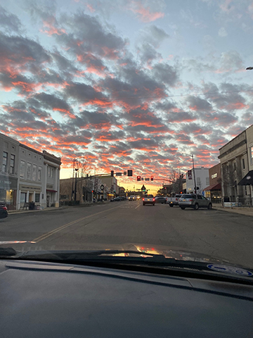 Photograph of a street in a small downtown at sunset.