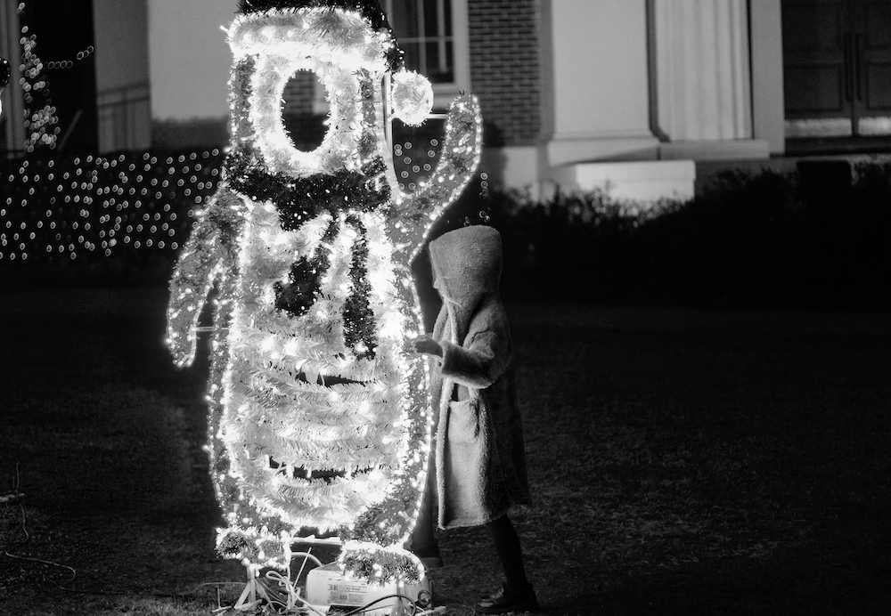 Photograph of a child playing with a penguin christmas decoration