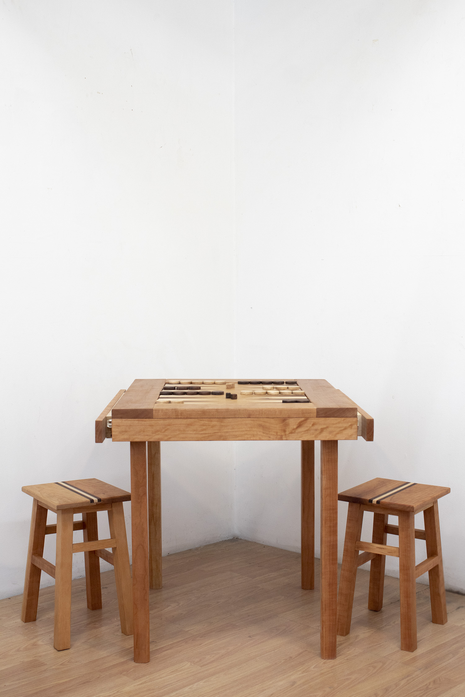 A simple table constructed with cherry wood. The center contains an inlaid backgammon board – constructed from cherry, maple, and walnut.