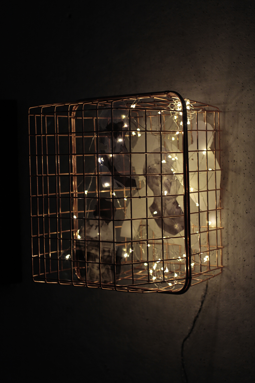 A photographed image of a box like cage with lights