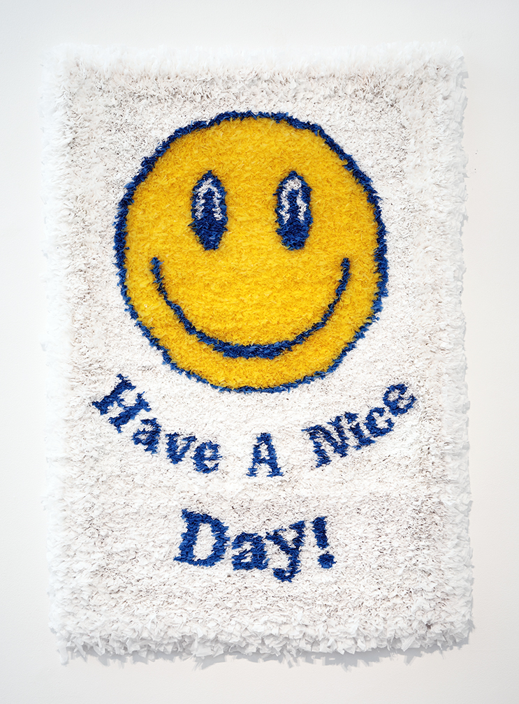 Yellow happy face over the blue words Have A Nice Day! on white background made from plastic bags. 