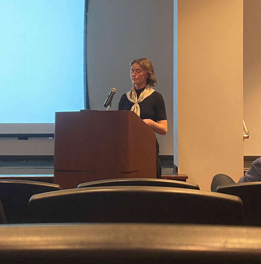 Tess Higginbotham presents at a lectern