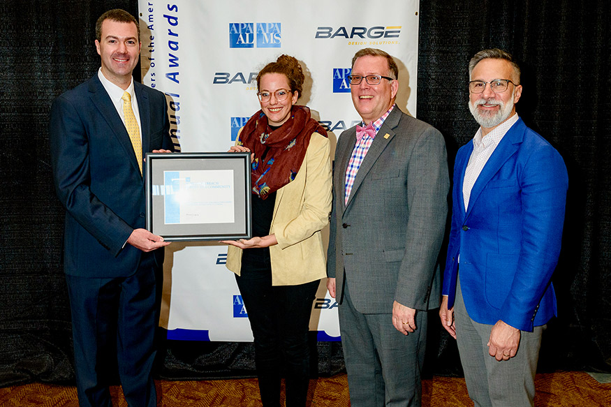 Anne Welch, second from left, accepts the Best Public Outreach Award. Presenting the award are Thomas Gregory, left, with Kurt Christiansen and Joel Albizo. 