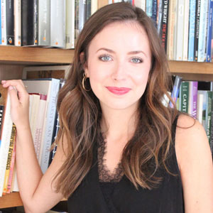 Meredith Hutto poses in front of book shelf