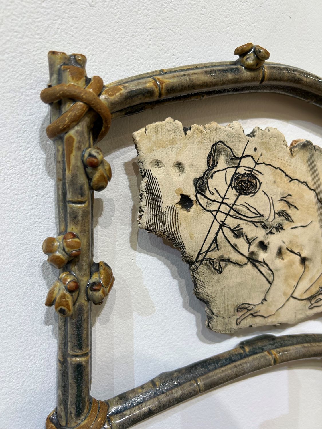 Detail shot of Rhinella marina, depicting the Cane Toad on a stoneware slab with a frame of sugar cane and flies made from stoneware clay, with Rutile Green glaze. 