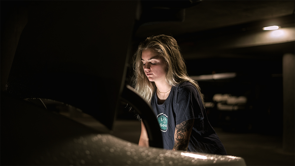 A photograph of a girl, her face being lit up by a light